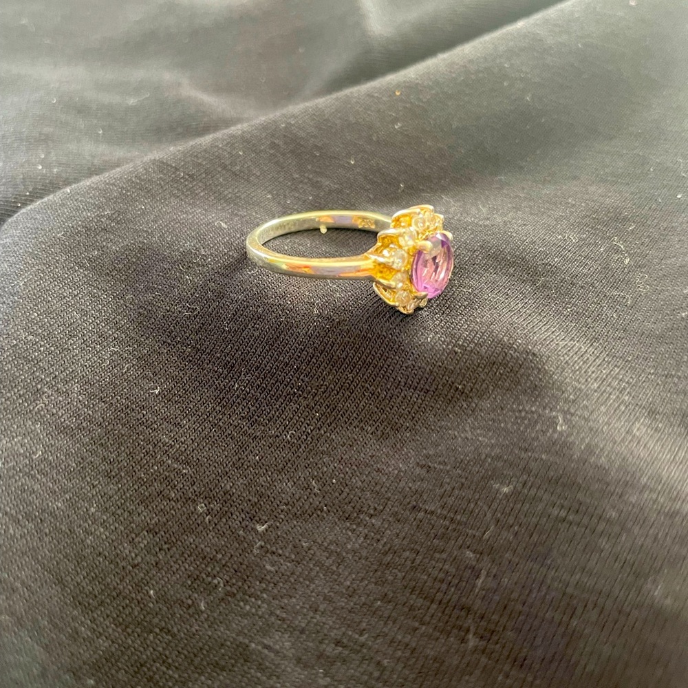 Amethyst stone surrounded by zirconia stones. Silver band.